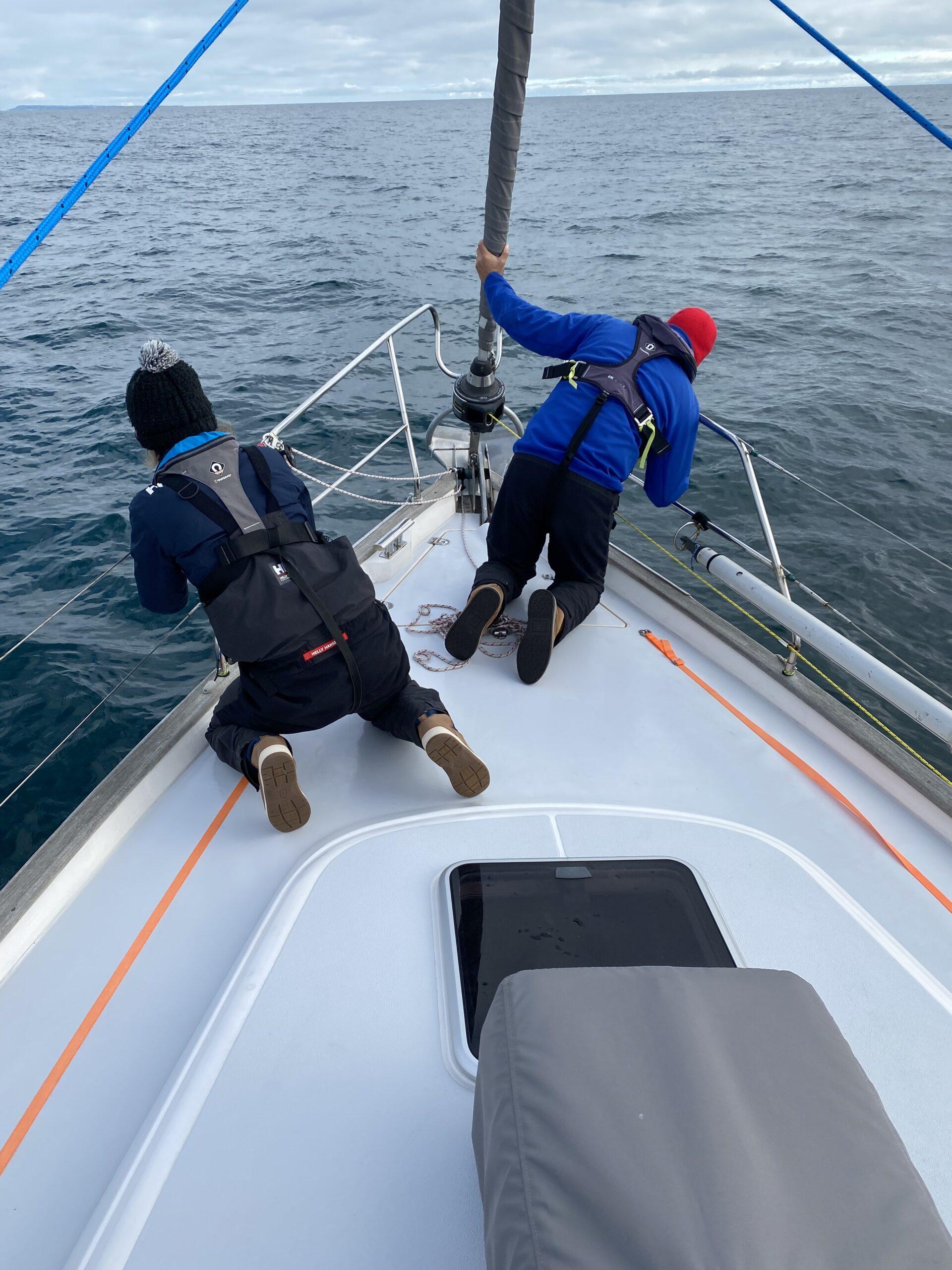 Chris and Cat spotting dolphins on the bow of Yanula Blue